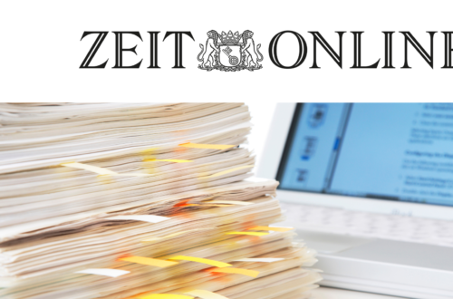 Oben rechts sieht man das Logo von Zeitonline. Darunter ist ein Bild von einem Stapel mit Unterlagen und dahinter steht ein Laptop.