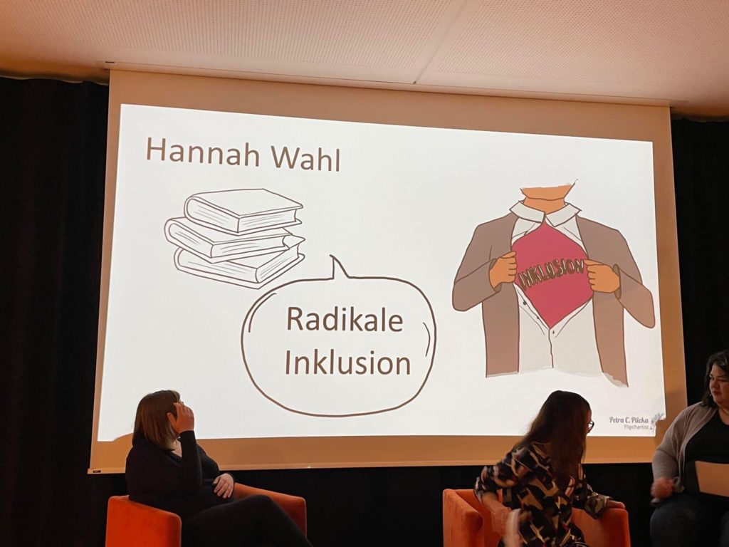 Man sieht die PowerPoint. Darauf steht Hannah Wahl und Radikale Inklusion. Auf der Folie ist eine Person gezeichnet die sich das Hemd aufhält. Auf dem T-Shirt steht Radikal.