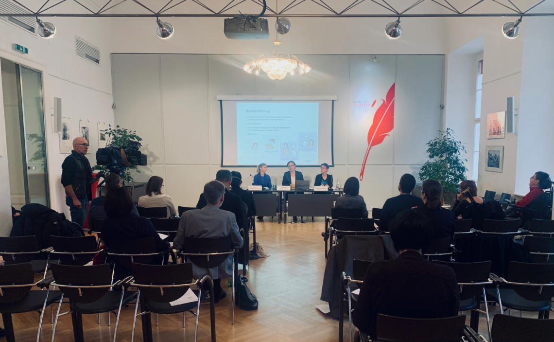 Man sieht den Raum der Pressekonferenz, bei der die Studie präsentiert wurde. Rechts und links sitzen Besucher*innen. Vorne sitzen am Podium: Anna Schachner, Hemma Mayrhofer, Sabine Mandl.